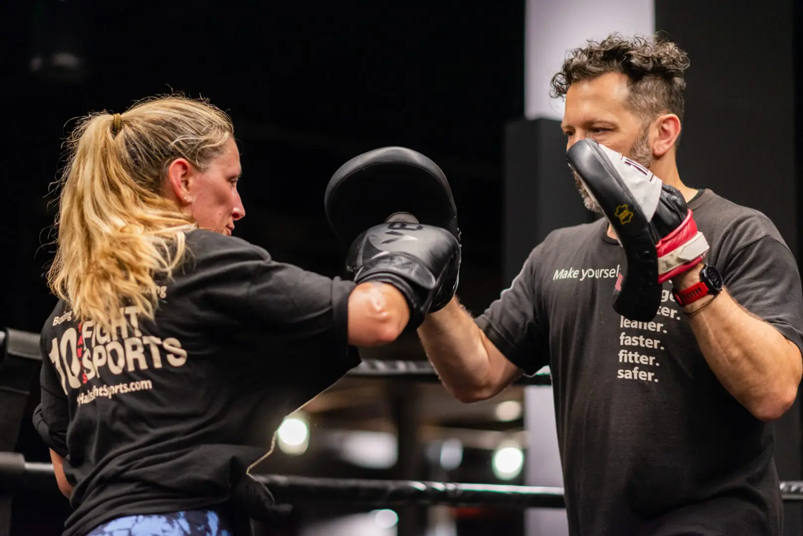 A woman and man are boxing in the ring.